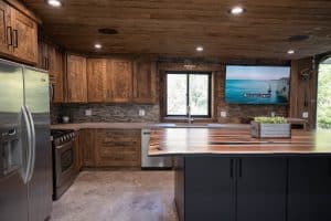 custom wood cabinets with black island and wood countertop